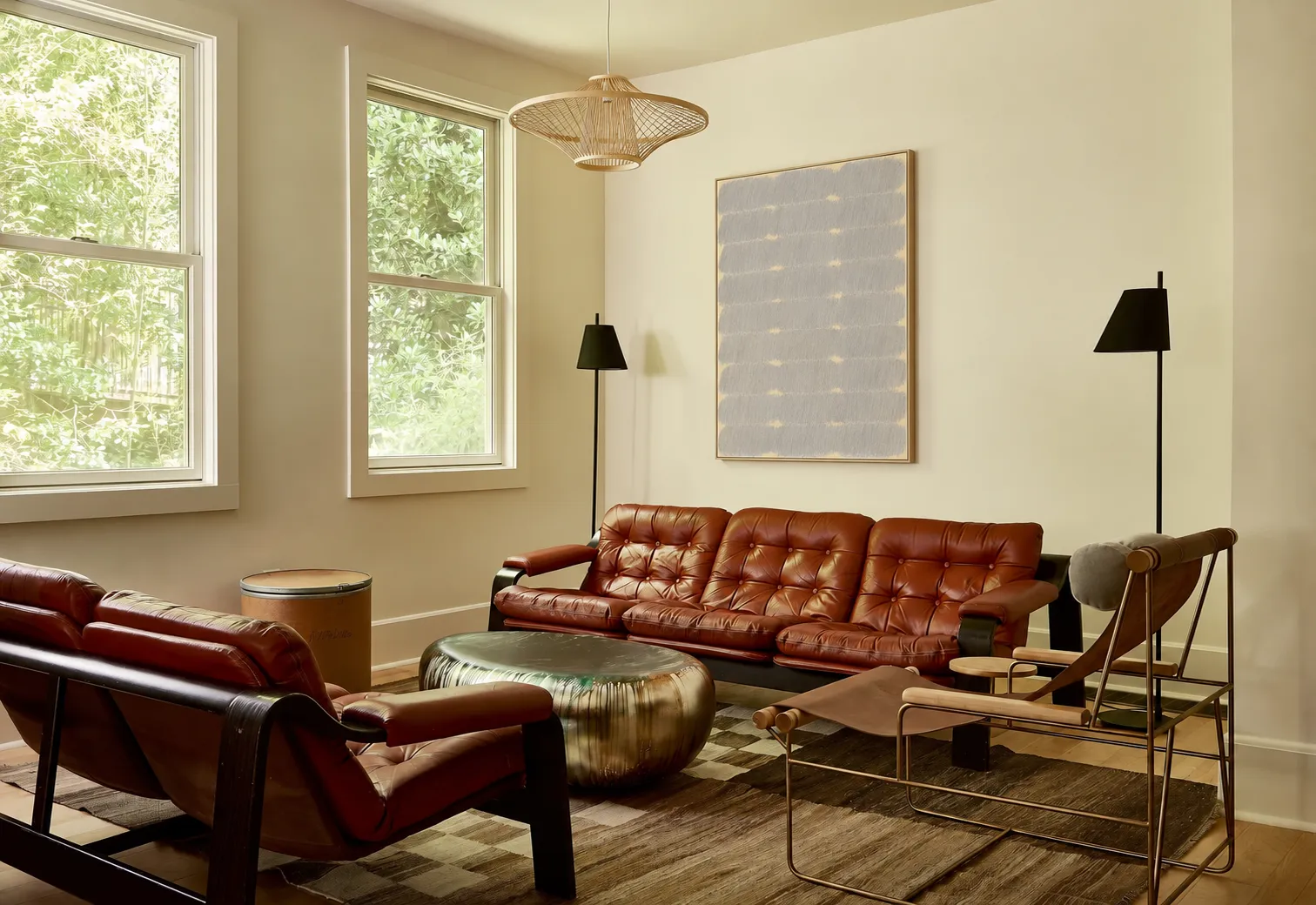 A lounge with leather sofas and a large textured artwork